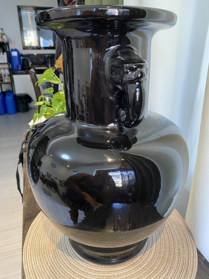 Large Black Ceramic Vase with Animal Head Handles (Category: Vases & Decorative Bowls) located in San Pedro. Submitted by jingay81 (Listing ID 1468708555, Image 3). Description: - Large black ceramic vase with a sleek high-gloss finish - Features detailed animal head handles on both sides - Elegant flared rim and wide bulbous body - Note: Has a noticeable repair patch near the base, as shown in the last photo - Makes a bold statement piece for an