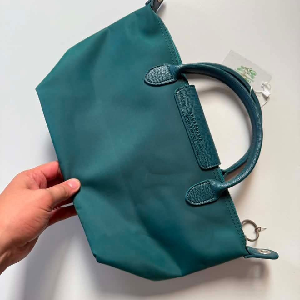 LC handbag (Category: Purses & Pouches) located in Manila. Submitted by mamapards17 (Listing ID 1468591279, Image 2). Description: teal-colored Longchamp Le Pliage-style short-handle handbag with a leather flap and snap closure..
