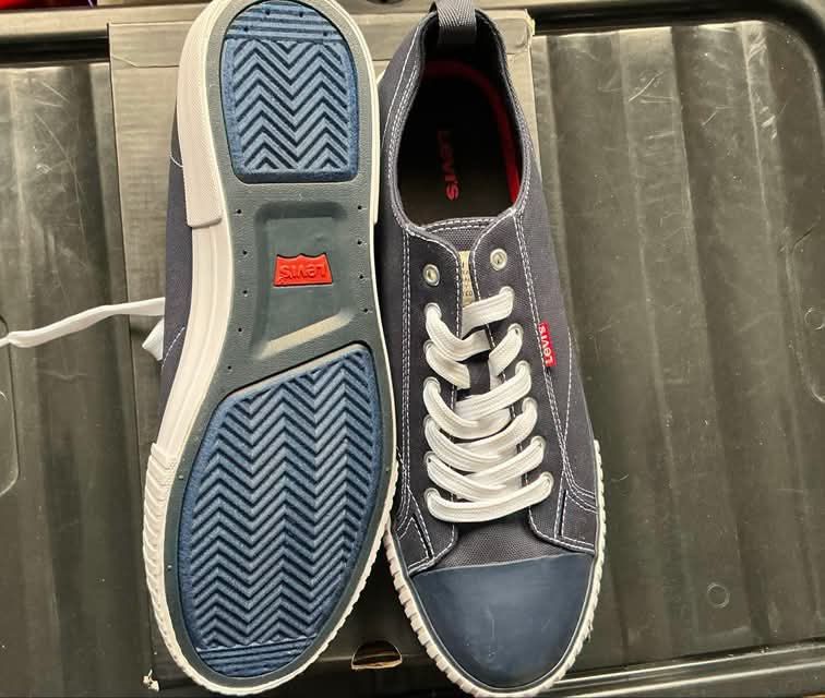 Levi's Canvas Blue Sneakers (Category: Casual Shoes) located in Quezon City. Submitted by gabrilloaaaaaaa (Listing ID 1468705544, Image 3). Description: - Brand: Levi's - Color: Navy blue canvas with white accents - Details: Blue toe caps, white rubber sidewalls, red logo tab on the side, red outsole logo - Features: Pull tabs at the heels and textured zig-zag tread pattern - Condition: Minor stain on one lace - Inclusion: Original box included.
