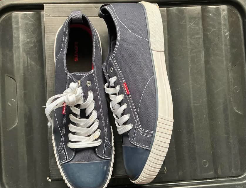 Levi's Canvas Blue Sneakers (Category: Casual Shoes) located in Quezon City. Submitted by gabrilloaaaaaaa (Listing ID 1468705544, Image 2). Description: - Brand: Levi's - Color: Navy blue canvas with white accents - Details: Blue toe caps, white rubber sidewalls, red logo tab on the side, red outsole logo - Features: Pull tabs at the heels and textured zig-zag tread pattern - Condition: Minor stain on one lace - Inclusion: Original box included.