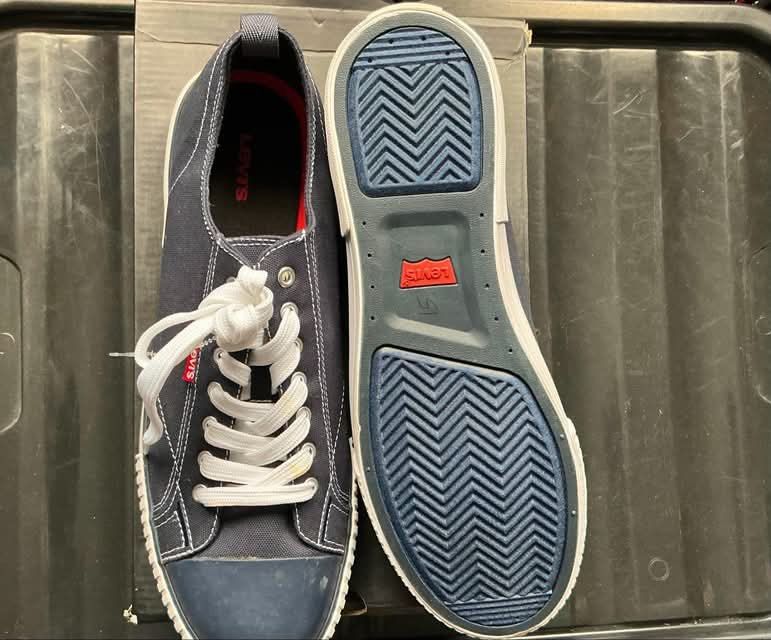 Levi's Canvas Blue Sneakers (Category: Casual Shoes) located in Quezon City. Submitted by gabrilloaaaaaaa (Listing ID 1468705544, Image 1). Description: - Brand: Levi's - Color: Navy blue canvas with white accents - Details: Blue toe caps, white rubber sidewalls, red logo tab on the side, red outsole logo - Features: Pull tabs at the heels and textured zig-zag tread pattern - Condition: Minor stain on one lace - Inclusion: Original box included.
