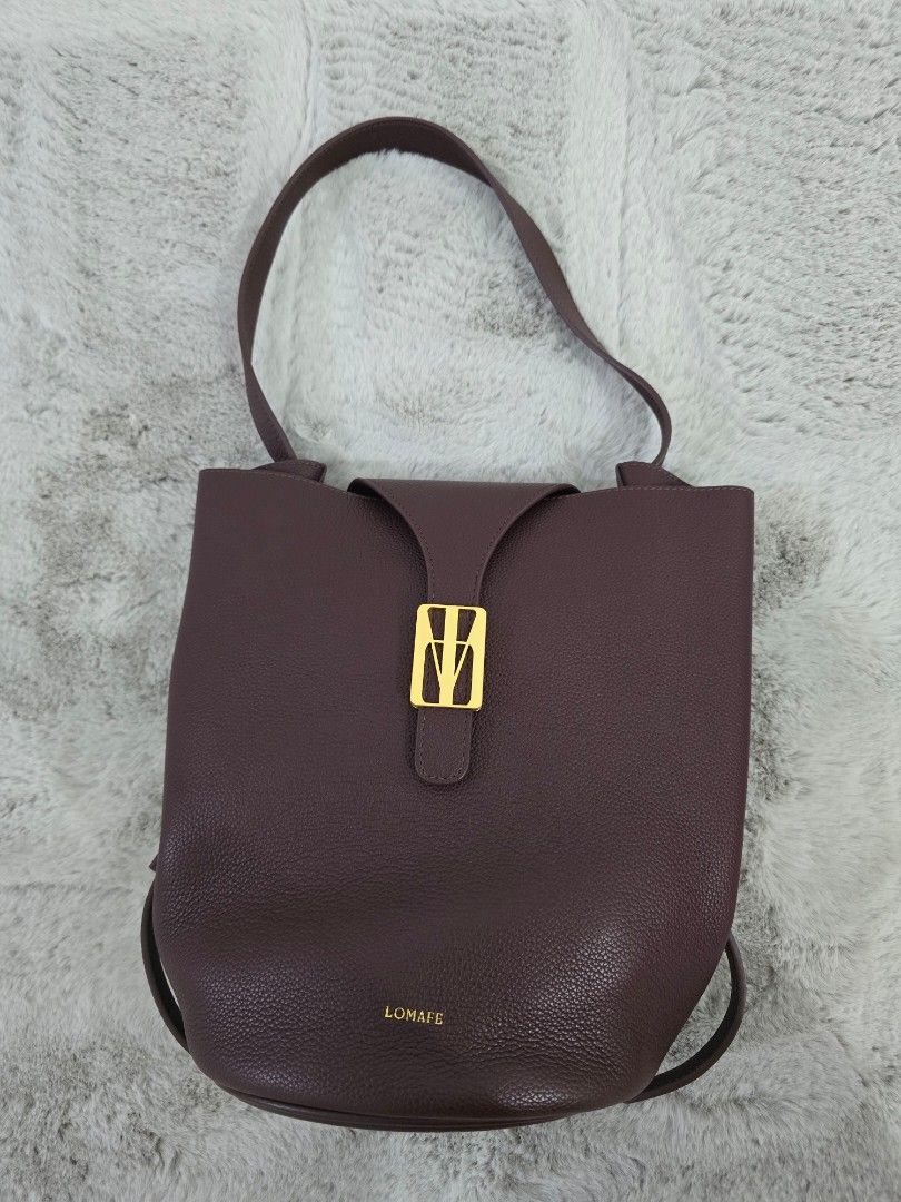 LOMAFE Velisse in Cabernet (Category: Cross-body Bags) located in San Fernando. Submitted by icasarmiepal.declutter (Listing ID 1468682353, Image 2). Description: - Color: Deep burgundy - Material: Textured pebbled leather - Design: Structured round circular base with clean edge stitching - Versatility: Includes an adjustable crossbody strap and a top handle loop - Usage: Compact everyday bag - Bought at SRP 13,800. Selling for 12,500 (slightly n