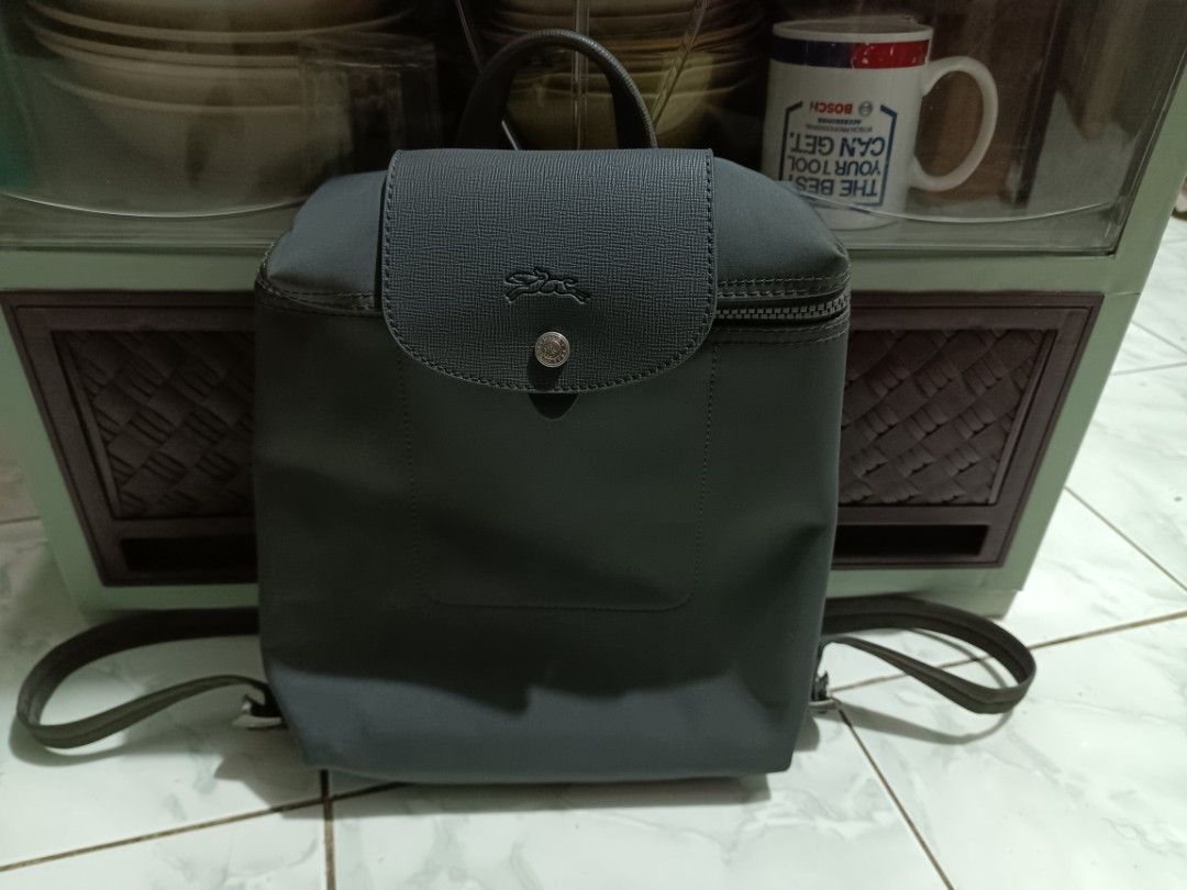 Longchamp grey nylon backpack (Category: Backpacks) located in Manila. Submitted by caaths_collection (Listing ID 1468690411, Image 1). Description: - what you see its what you get - grey nylon backpack - Flap top with snap button and secure main zipper closure - Adjustable dark grey webbing shoulder straps and top grab handle - Clean exterior and neat stitching throughout - Versatile design, ideal for daily commutes, work, or casual outings.