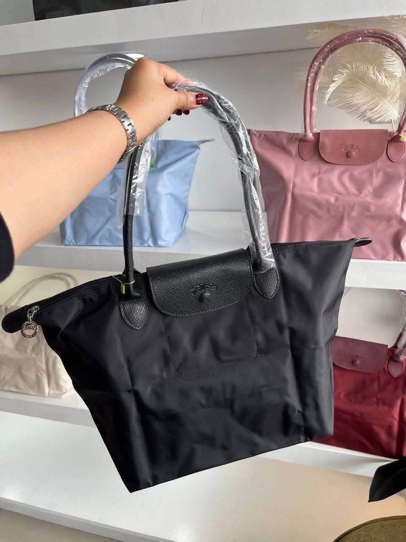 Longchamp Le Pliage Nylon Tote Bag (Category: Luxury Bags & Wallets) located in Manila. Submitted by sanghaya.mnl (Listing ID 1468546948, Image 3). Description: - Features signature leather flap closure and top handles (handles still wrapped in protective plastic) - Foldable design with secure snap button and zipper closure - Lightweight, everyday bag with a spacious interior - Available colours: pink, blue, black, maroon, and beige - Brand new a