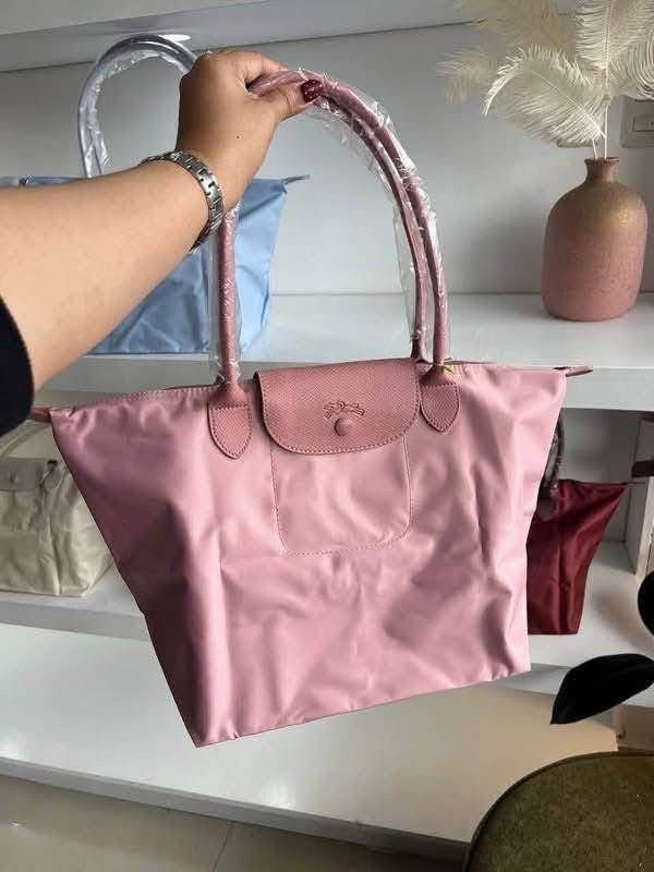 Longchamp Le Pliage Nylon Tote Bag (Category: Luxury Bags & Wallets) located in Manila. Submitted by sanghaya.mnl (Listing ID 1468546948, Image 1). Description: - Features signature leather flap closure and top handles (handles still wrapped in protective plastic) - Foldable design with secure snap button and zipper closure - Lightweight, everyday bag with a spacious interior - Available colours: pink, blue, black, maroon, and beige - Brand new a