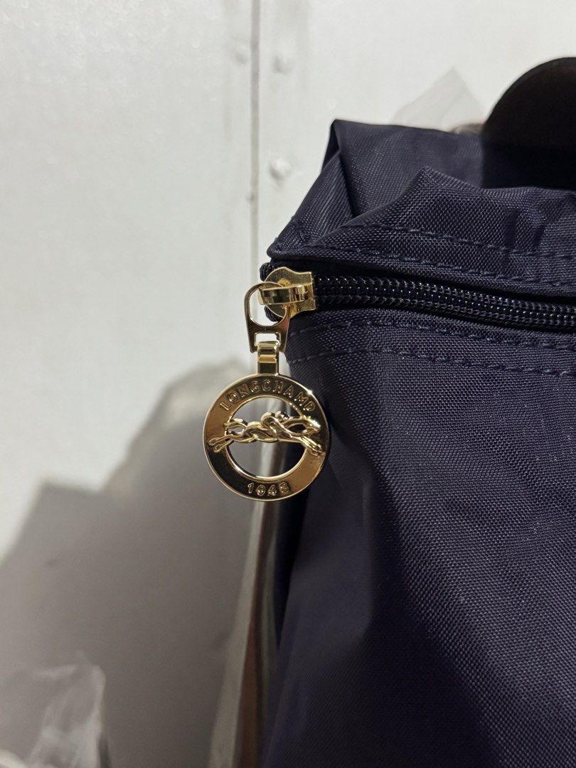 Longchamp Le Pliage Sac A Dos Backpack Purple (Category: Backpacks) located in Manila. Submitted by reinjoseph (Listing ID 1468673043, Image 3). Description: - Authentic Longchamp Le Pliage Backpack - Color: Purple with Brown Leather Flap & Top Handle - Hardware: Gold-tone with signature horse medallion zipper pull - Model: L1699089645 (Made in Tunisia) - Inclusions: Original paper bag and care booklet - Condition: Clean nylon body and sturdy lea