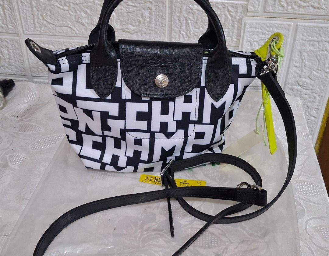 Longchamp Top Handle Bag Black White Letter Print (Category: Luxury Bags & Wallets) located in Manila. Submitted by katkween23 (Listing ID 1468513589, Image 2). Description: - Authentic Longchamp top handle bag - Trendy black and white letter print pattern - Includes a detachable black leather strap and lime green accent tag - Secure top flap with snap closure and zip entry - Interior features a slip pocket and Longchamp branding - Complete with 