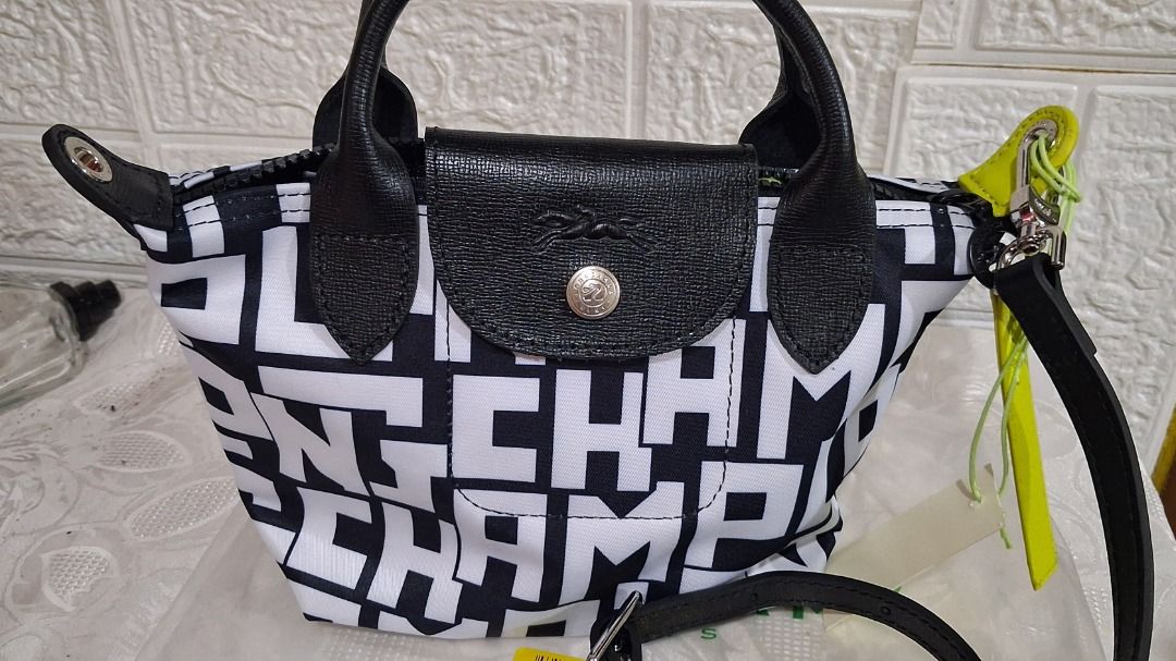 Longchamp Top Handle Bag Black White Letter Print (Category: Luxury Bags & Wallets) located in Manila. Submitted by katkween23 (Listing ID 1468513589, Image 1). Description: - Authentic Longchamp top handle bag - Trendy black and white letter print pattern - Includes a detachable black leather strap and lime green accent tag - Secure top flap with snap closure and zip entry - Interior features a slip pocket and Longchamp branding - Complete with 