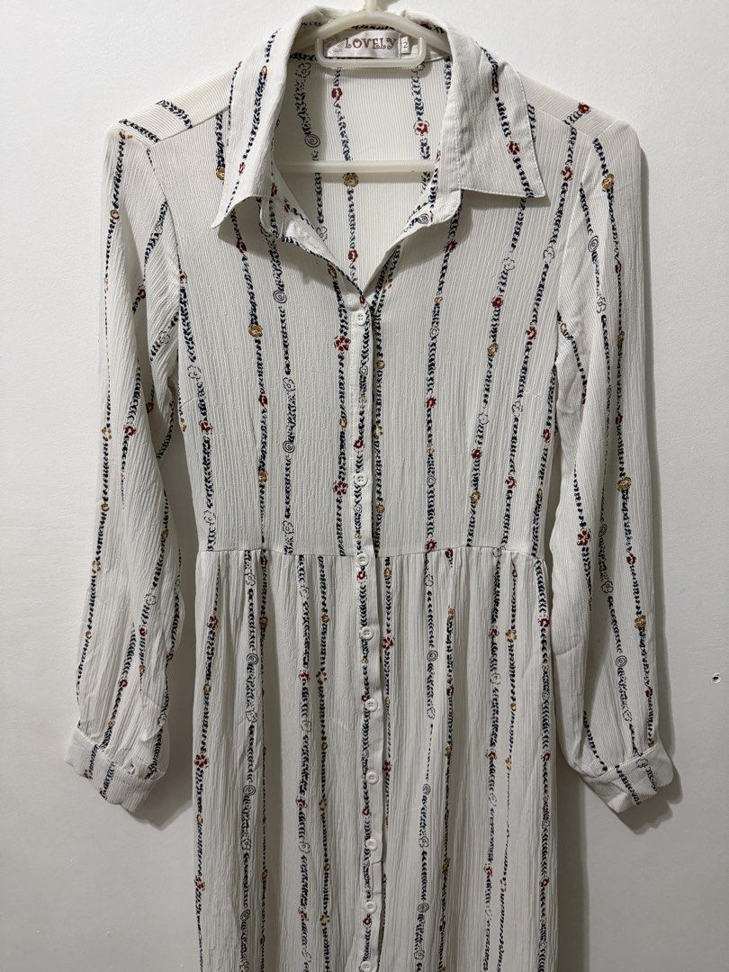 Long-Sleeve Shirt Dress (Category: Dresses) located in Malolos. Submitted by eadiana (Listing ID 1468618991, Image 1). Description: - Brand: Lovely - Style: White long-sleeve shirt dress with vertical printed stripes, florals, and swirls - Fit: Collared neckline, button-down front, and fitted waist with a matching fabric belt - Details: Lightweight pleated fabric, long sleeves with button cuffs - Length: Midi to maxi (depending on height) - Condi