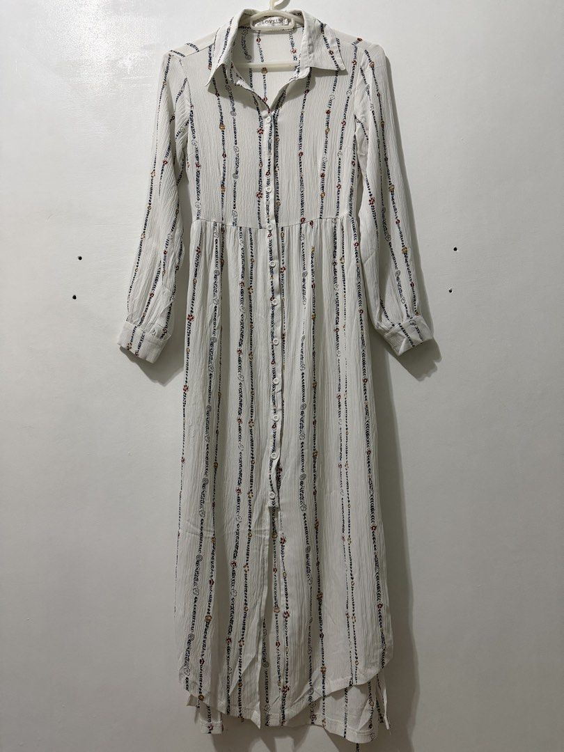 Long-Sleeve Shirt Dress (Category: Dresses) located in Malolos. Submitted by eadiana (Listing ID 1468618991, Image 2). Description: - Brand: Lovely - Style: White long-sleeve shirt dress with vertical printed stripes, florals, and swirls - Fit: Collared neckline, button-down front, and fitted waist with a matching fabric belt - Details: Lightweight pleated fabric, long sleeves with button cuffs - Length: Midi to maxi (depending on height) - Condi