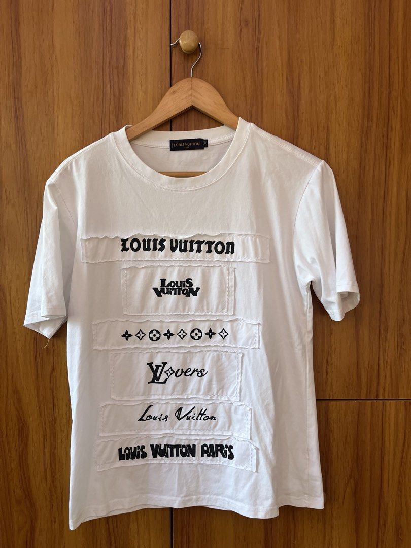 Louis Vuitton Multi Patchwork Logo White T-Shirt (Category: Shirts) located in Manila. Submitted by christian048 (Listing ID 1468649417, Image 2). Description: - Size: Large - Color: White - Material: Comfortable cotton - Design: Classic crew neck with multiple black graphic logo patches on the chest - Back: Clean with no prints - Condition: Clean, wash tag with care instructions included - Dimes: Width - 19 - Length - 25 - unnoticeable washable 