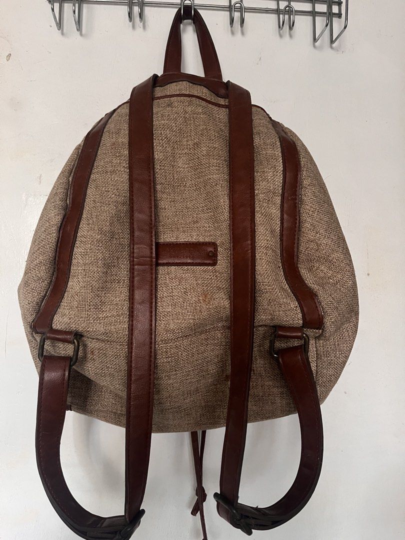 Lucky Brand Burlap and Leather Backpack (Category: Backpacks) located in Manila. Submitted by prelovedpick.com (Listing ID 1468620607, Image 2). Description: - Brand: Lucky Brand - Material: Textured burlap with rich brown leather trim - Closure: Flap with buckle detail and secure drawstring top - Straps: Adjustable brown leather shoulder straps - Interior: Bright red fabric lining with zipper pockets for organization - Style: Earthy, casual, and
