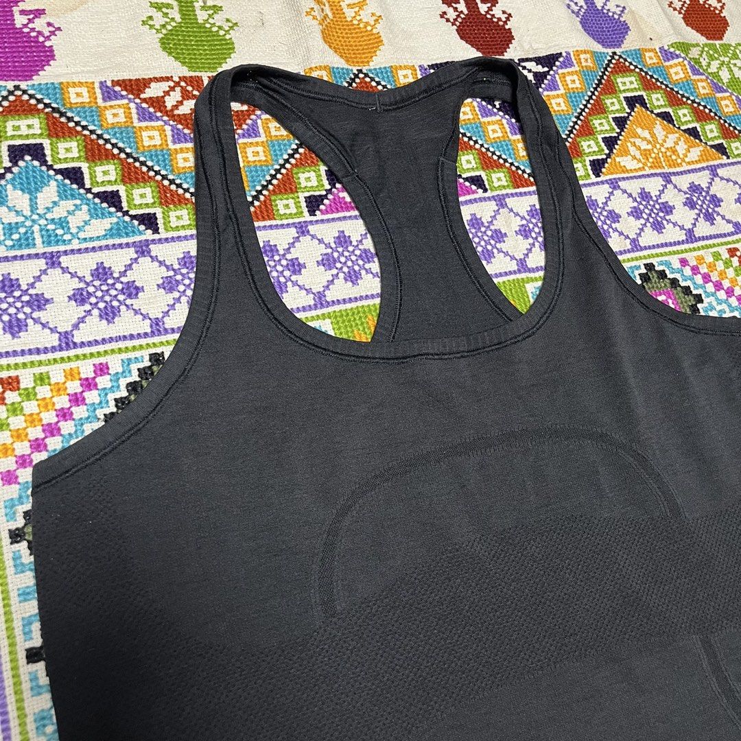 Lululemon Black Racerback Tank Top (Category: Activewear) located in Dagupan City. Submitted by vernzkee (Listing ID 1468525148, Image 2). Description: - Authentic Lululemon racerback tank top in classic black - Seamless, stretchy fabric for ultimate workout comfort - Stylish knit texture patterns along the back and sides - Signature reflective Lululemon logo on the upper back for visibility - Size indicator visible on the inside hem - Ideal for 
