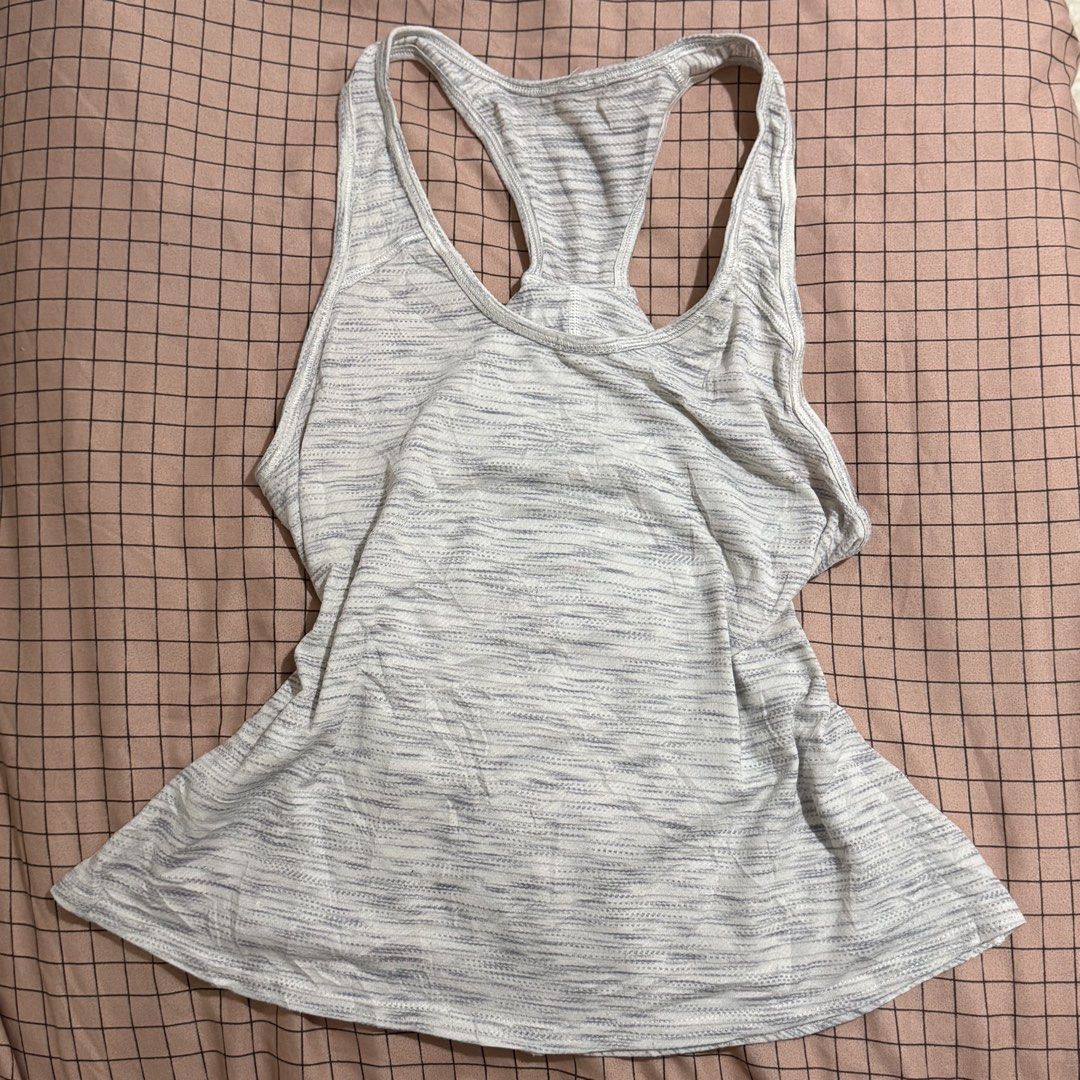 Lululemon grey heathered racerback tank top 🤍 (Category: Activewear) located in Pasay City. Submitted by bellita_05 (Listing ID 1468668270, Image 2). Description: • Colour: Light grey/white heathered • Style: Racerback athletic tank • Logo visible • Size: Tag cut • Measurements: Width 35 cm | Length 20 in • Pre-loved condition Perfect for gym, yoga, pilates, or everyday athleisure wear!.