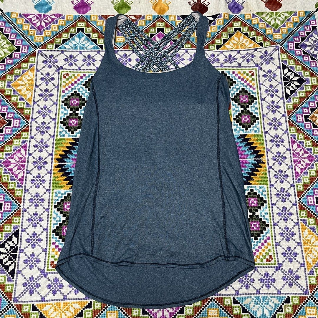 lululemon heathered blue strappy back workout tank top (Category: Activewear) located in Dagupan City. Submitted by vernzkee (Listing ID 1468524821, Image 1). Description: Lululemon athletic tank top in heathered blue. Built-in bra with patterned strappy back design. High-low curved hemline. Classic signature logo printed near bottom left hem. Measured flat width across the chest band is about 13 inches. Breathable athletic fabric. Location: Dagu