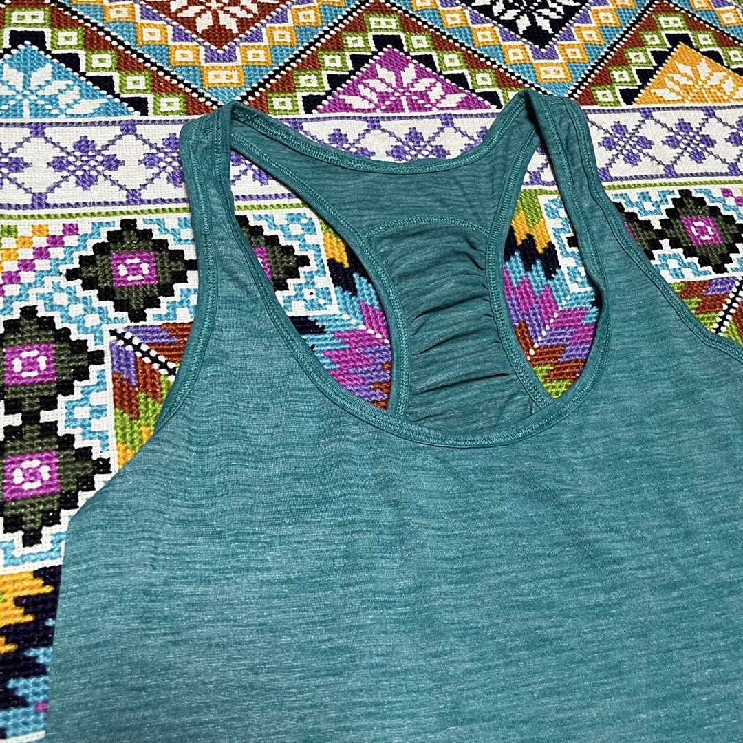 Lululemon Teal Athletic Racerback Tank Top (Category: Activewear) located in Dagupan City. Submitted by vernzkee (Listing ID 1468524083, Image 2). Description: - Brand: Lululemon - Color: Heathered teal green - Style: Racerback with upper back ruching detail - Fit: Flattering curved hemline - Details: Signature reflective omega logo on the lower left hem - Fabric: Breathable, stretchy athletic material Location: Dagupan City, Pangasinan MOP: Gcas