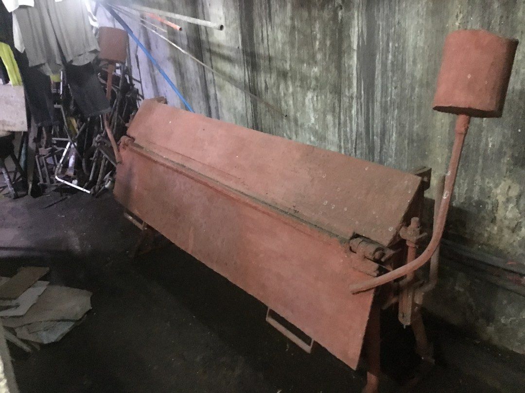 Manual Sheet Metal Bending Machine Folder (Category: Construction Tools & Equipment) located in Manila. Submitted by roberto.enriquez (Listing ID 1468689511, Image 3). Description: - Heavy-duty manual metal brake, ideal for workshop fabrication and sheet metal bending - Solid and sturdy construction finished in reddish-brown paint - Equipped with two side counterweight handles and manual leverage operation - Condition: Shows some wear, surface ru