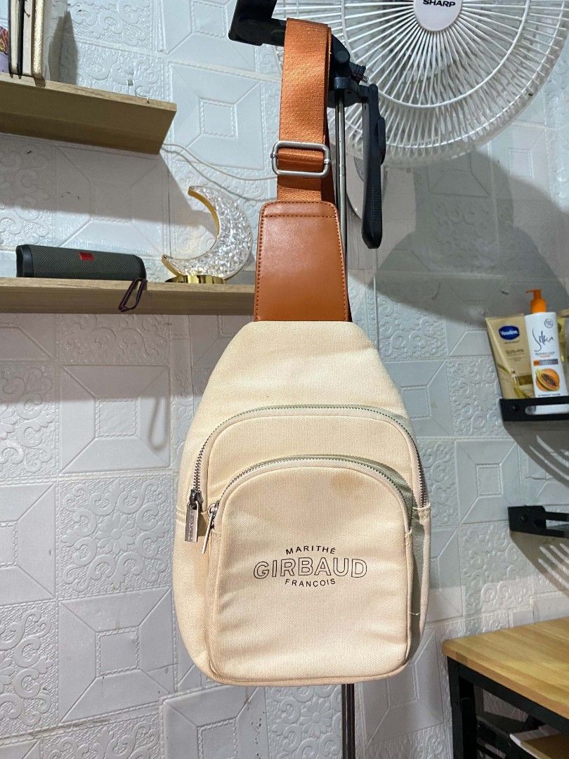 Marithe + Francois Girbaud Canvas Sling Bag Beige (Category: Cross-body Bags) located in Koronadal. Submitted by thrifturight (Listing ID 1468627570, Image 1). Description: - Brand: Marithe + Francois Girbaud - Style: Canvas sling bag - Color: Beige with brown strap - Hardware: Silver-tone with branded zipper pulls - Exterior: Front zippered pockets - Interior: Fabric-lined with brown leather logo patch and inner pocket - Condition: Visible disco