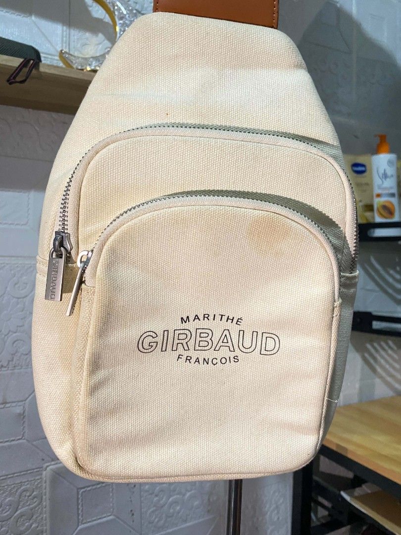 Marithe + Francois Girbaud Canvas Sling Bag Beige (Category: Cross-body Bags) located in Koronadal. Submitted by thrifturight (Listing ID 1468627570, Image 2). Description: - Brand: Marithe + Francois Girbaud - Style: Canvas sling bag - Color: Beige with brown strap - Hardware: Silver-tone with branded zipper pulls - Exterior: Front zippered pockets - Interior: Fabric-lined with brown leather logo patch and inner pocket - Condition: Visible disco