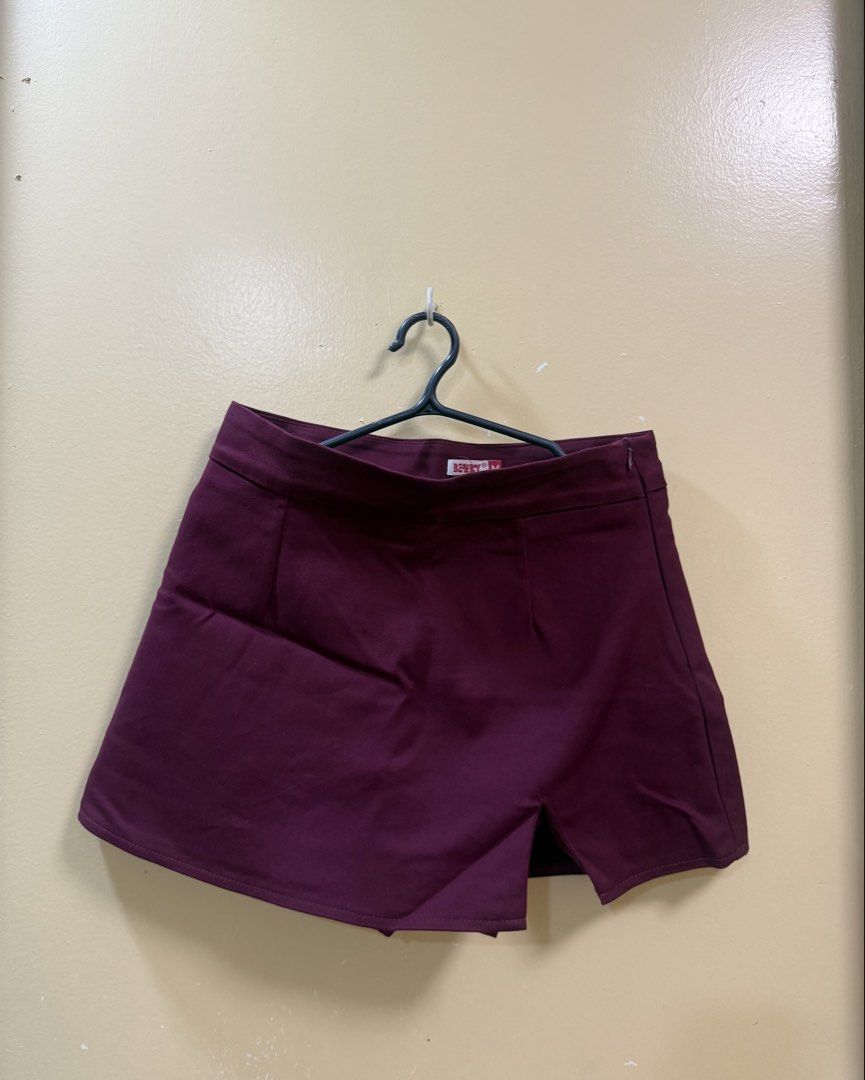Maroon Asymmetrical Skort Size M (Category: Skirts) located in Makati City. Submitted by shoprory (Listing ID 1468593127, Image 1). Description: - Color: Maroon - Size: Medium (tag inside) - Design: High waist with asymmetrical front slit and pleated back detail - Closure: Side zipper - Versatile piece great for casual outings or dressing up.