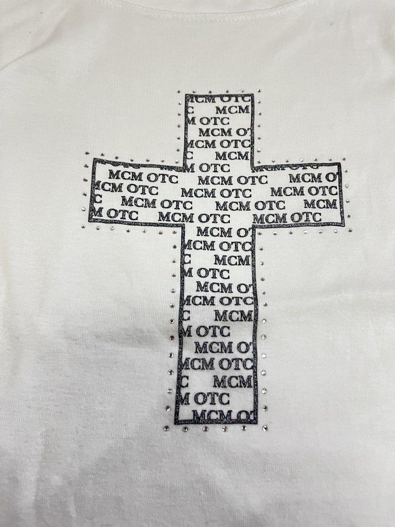 MCM OTC White Rhinestone Cross Tee Size L (Category: Shirts) located in Mabalacat. Submitted by aas_thriftfings (Listing ID 1468573077, Image 2). Description: - Color: White - Design: Rhinestone-studded cross graphic with MCM OTC text patterns - Size: L (includes MCM branded side tags and inner collar tag) - Pit-to-Pit: Approx. 16 inches - Length: Approx. 22 inches - Condition: Good as new, message for inquiries!.