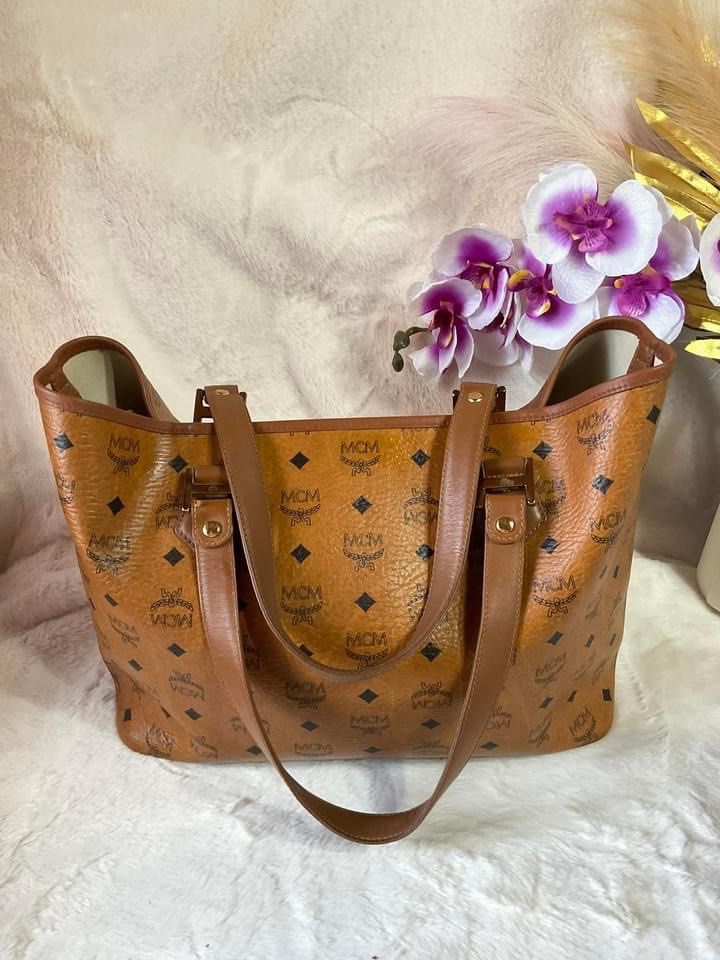 MCM Visetos Monogram Stripe Tote Bag Brown Orange (Category: Luxury Bags & Wallets) located in La Trinidad. Submitted by naravincollections (Listing ID 1468541856, Image 2). Description: - Brand: MCM, Authentic - Style: Visetos Monogram Tote - Design: Classic brown monogram with a vibrant orange and black vertical stripe - Hardware: Gold-tone, in excellent condition, no tarnish - Straps & Trim: Tan leather double shoulder straps *** Recoloring do