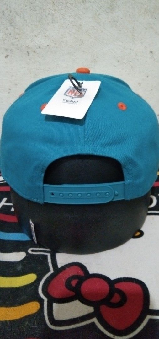 Miami Dolphins NFL Team Headwear Snapback Hat (Category: Caps & Hats) located in Manila. Submitted by tonycess16 (Listing ID 1468526286, Image 2). Description: - Brand: NFL Team Headwear - Team: Miami Dolphins - Condition: Brand new with original tags attached - Colors: Teal crown with orange top button and matching brim underside - Details: Embroidered team logo on front, clean interior taping and stitching - Fit: Adjustable plastic snap closure
