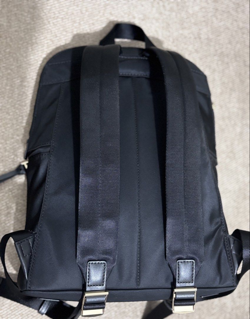 Michael Kors Black Nylon Backpack (Category: Backpacks) located in Mandaluyong City. Submitted by annaziki2001 (Listing ID 1468709724, Image 2). Description: - Brand: Michael Kors - Material: Durable black nylon with gold-tone hardware - Exterior: Front zipped pocket with double pullers and leather-like pull tabs - Straps: Adjustable black fabric shoulder straps with leather trim and top carry handle - Interior: Clean dark fabric lining, secure z