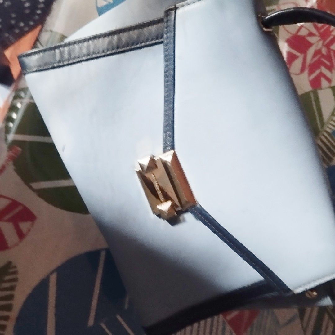 Michael Kors Blue and Black Leather Handbag (Category: Cross-body Bags) located in Manila. Submitted by lene48 (Listing ID 1468580205, Image 2). Description: - Brand: Michael Kors - Color: Light blue with black trim - Hardware: Gold-tone - Closure: Front flap with engraved logo lock clasp - Includes: Top handle and strap attachments (strap not included unless specified) - Condition: Pre-loved with minor scuffs, dark marks on the leather surface, 
