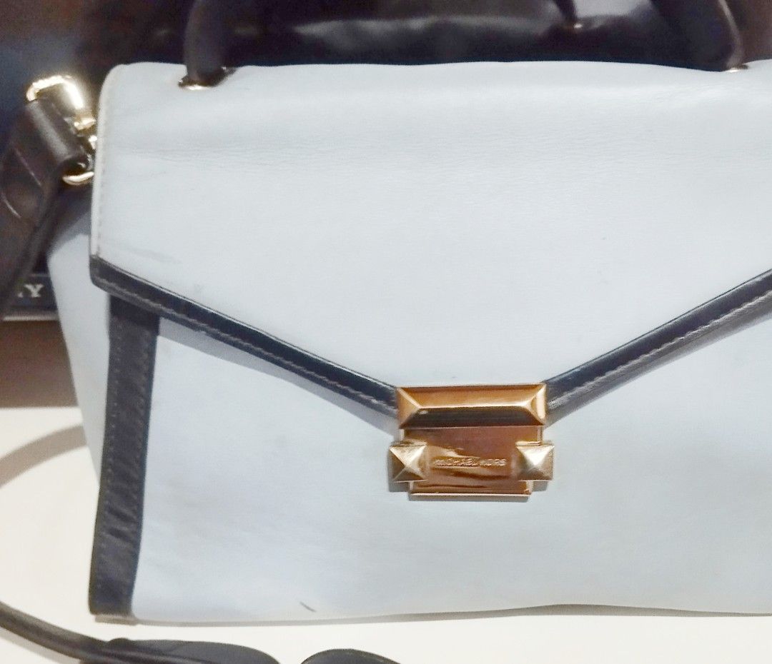 Michael Kors Blue and Black Leather Handbag (Category: Cross-body Bags) located in Manila. Submitted by lene48 (Listing ID 1468580205, Image 1). Description: - Brand: Michael Kors - Color: Light blue with black trim - Hardware: Gold-tone - Closure: Front flap with engraved logo lock clasp - Includes: Top handle and strap attachments (strap not included unless specified) - Condition: Pre-loved with minor scuffs, dark marks on the leather surface, 