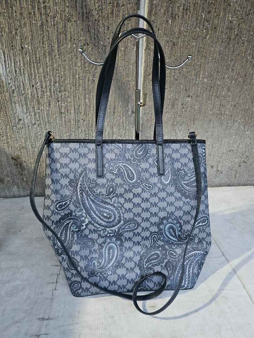 Michael kors dual sling tote bag (Category: Tote Bags) located in Manila. Submitted by onlinesmartshopping12 (Listing ID 1468501237, Image 2). Description: Stylish Michael Kors tote bag featuring a unique paisley pattern. It has black handles and a detachable shoulder strap. The interior lining is a light beige color. The bag's dimensions are approximately 14 inches in length and 12 inches in height..