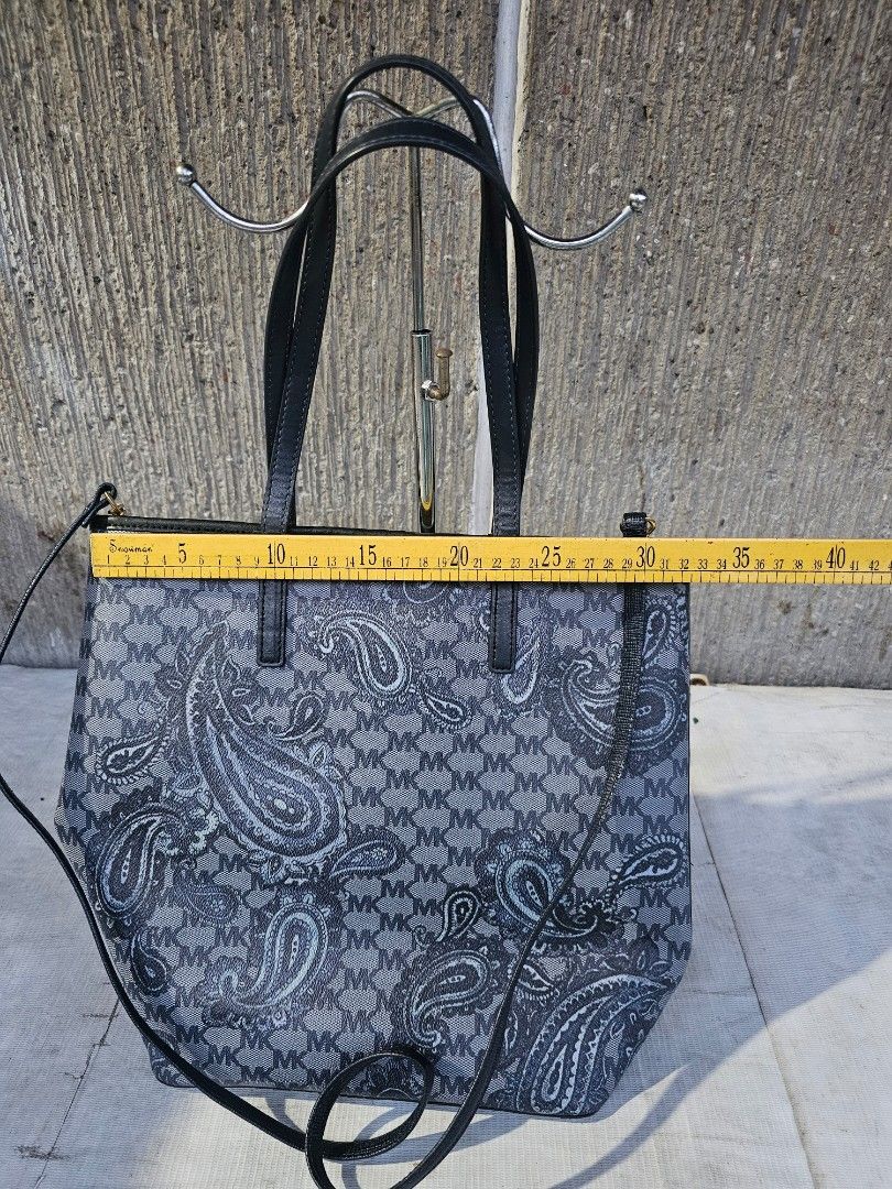 Michael kors dual sling tote bag (Category: Tote Bags) located in Manila. Submitted by onlinesmartshopping12 (Listing ID 1468501237, Image 3). Description: Stylish Michael Kors tote bag featuring a unique paisley pattern. It has black handles and a detachable shoulder strap. The interior lining is a light beige color. The bag's dimensions are approximately 14 inches in length and 12 inches in height..