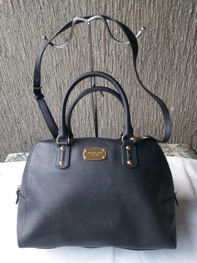 Michael kors mk bag (Category: Cross-body Bags) located in Manila. Submitted by onlinesmartshopping12 (Listing ID 1468500295, Image 1). Description: decluttering no issue1 Black satchel bag with gold-tone hardware. Features a top zipper closure and dual top handles. Includes a detachable shoulder strap. The bag has a gold Michael Kors logo on the front. The interior lining is grey. The bag has a tag.