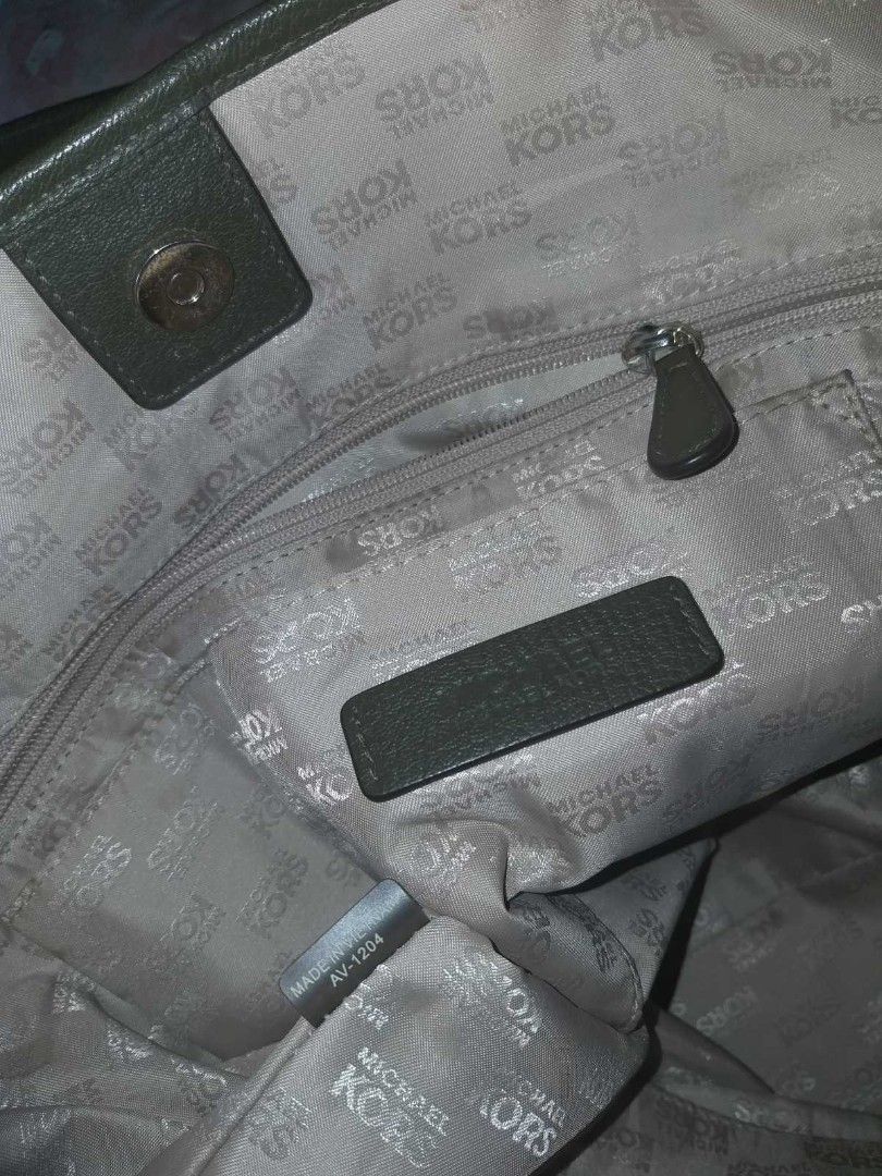Michael kors neverfull tote bag (Category: Tote Bags) located in Manila. Submitted by onlinesmartshopping12 (Listing ID 1468500134, Image 3). Description: Olive green tote bag by Michael Kors. Features a large main compartment with a zip closure and an interior pocket. The bag has double top handles and a metal MK logo on the front. The bottom of the bag has gold-toned metal feet. The interior lining is printed with the Michael Kors logo..