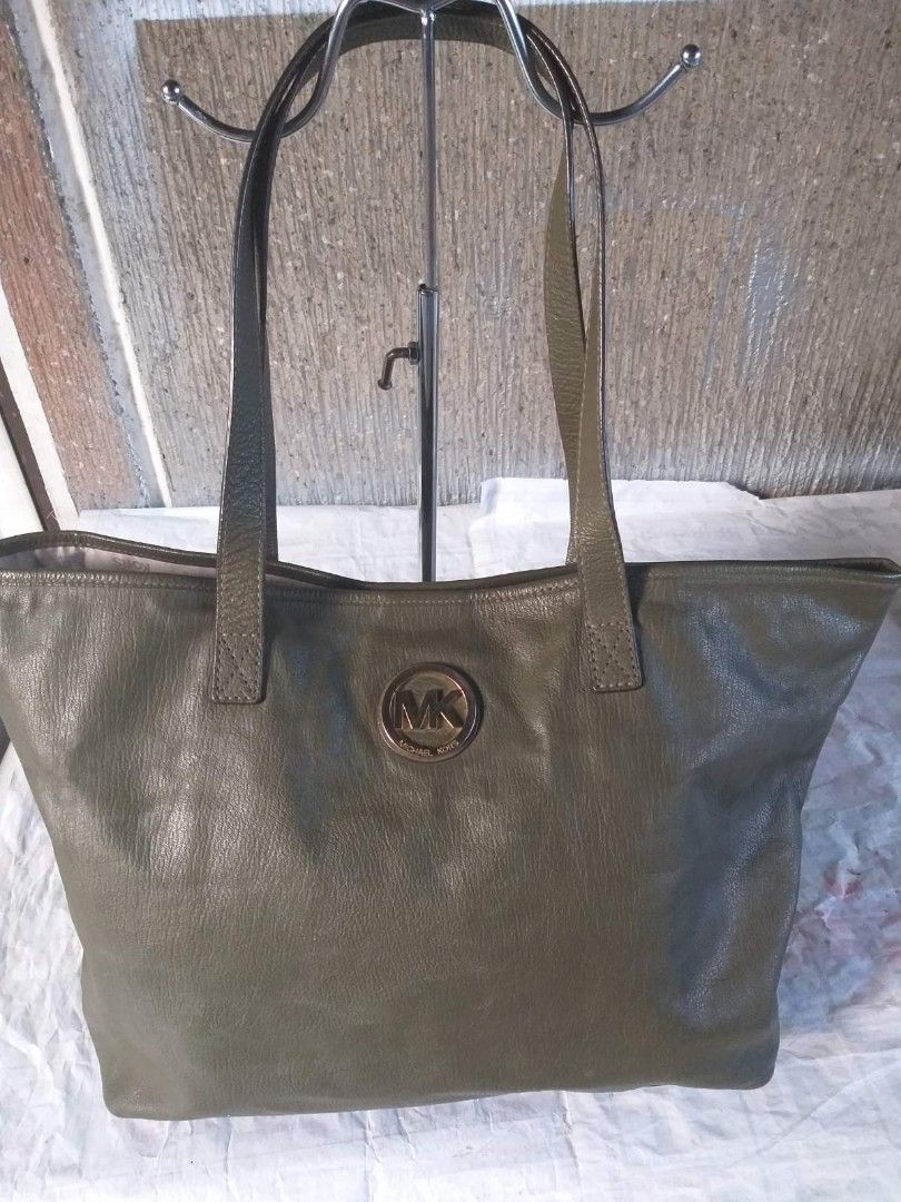 Michael kors neverfull tote bag (Category: Tote Bags) located in Manila. Submitted by onlinesmartshopping12 (Listing ID 1468500134, Image 2). Description: Olive green tote bag by Michael Kors. Features a large main compartment with a zip closure and an interior pocket. The bag has double top handles and a metal MK logo on the front. The bottom of the bag has gold-toned metal feet. The interior lining is printed with the Michael Kors logo..