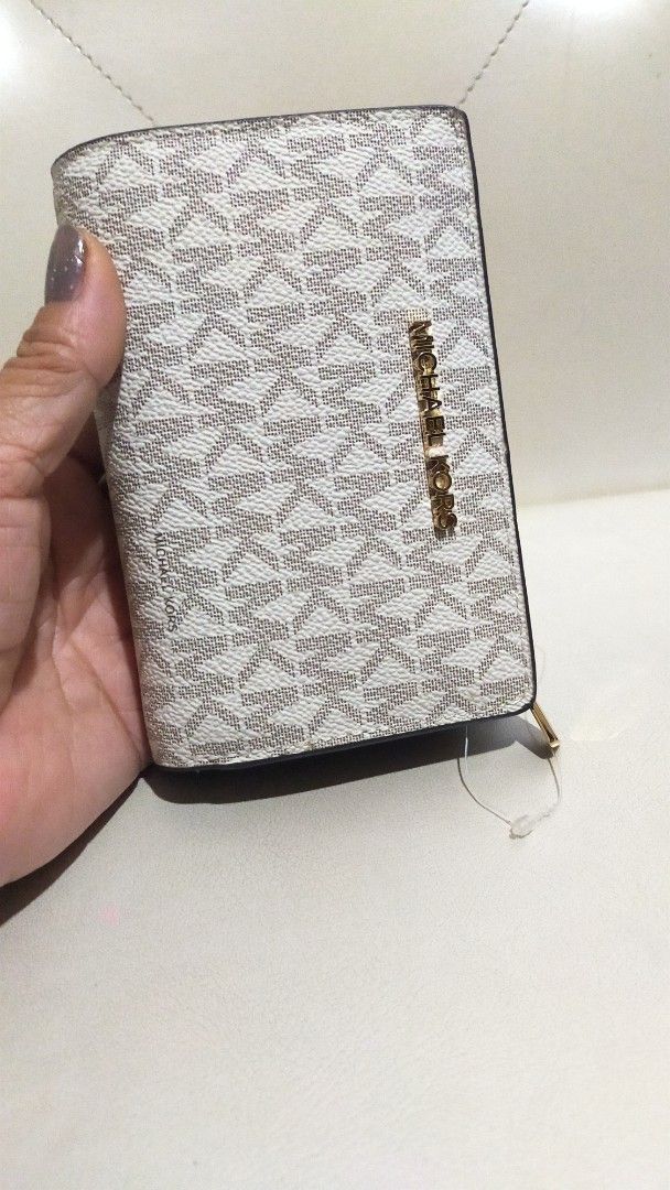 Michael Kors Signature Brown White Medium Wallet (Category: Luxury Bags & Wallets) located in Manila. Submitted by angelcatam30011 (Listing ID 1468521155, Image 2). Description: - Brand: Michael Kors - Design: White and brown signature print with gold-tone hardware - Closure: Secure snap button closure - Interior: Brown leather with multiple card slots and a zippered coin compartment - Condition: Brand new with original protective foam inserts st