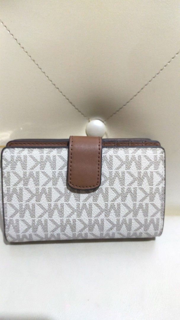 Michael Kors Signature Brown White Medium Wallet (Category: Luxury Bags & Wallets) located in Manila. Submitted by angelcatam30011 (Listing ID 1468521155, Image 3). Description: - Brand: Michael Kors - Design: White and brown signature print with gold-tone hardware - Closure: Secure snap button closure - Interior: Brown leather with multiple card slots and a zippered coin compartment - Condition: Brand new with original protective foam inserts st