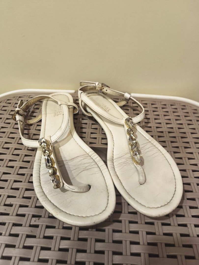 Michael Kors White Leather Crystal Embellished Flat Sandals (Category: Flats & Sandals) located in Baguio. Submitted by zia_zab (Listing ID 1468530286, Image 1). Description: - Brand: Michael Kors - Style: White leather flat sandals with T-strap and clear crystal stones - Hardware: Gold-tone adjustable ankle buckle - Condition: Pre-loved; soles show scuffing and insoles have minor creasing/discoloration - Details: All rhinestones are complete and