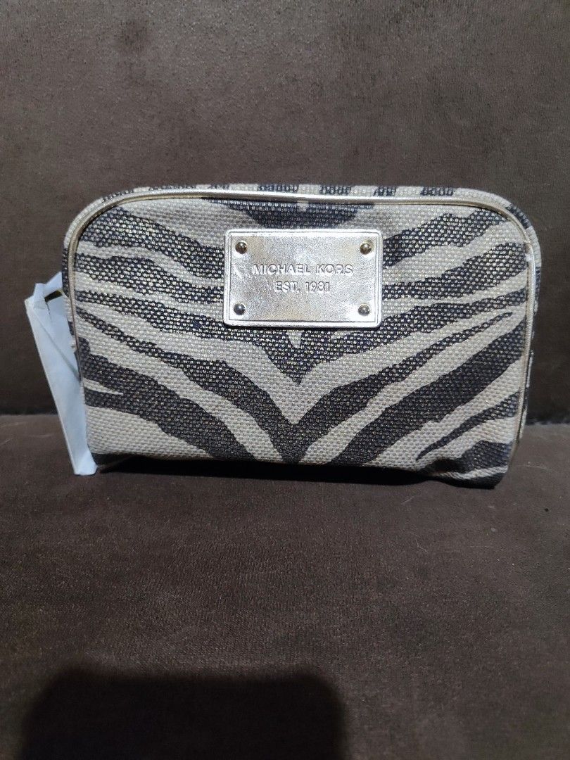 Michael Kors Zebra Print Cosmetic Pouch (Category: Purses & Pouches) located in Paniqui. Submitted by arlenepari29210 (Listing ID 1468687113, Image 1). Description: - Brand: Michael Kors - Design: Bold zebra print fabric with front gold metal plaque - Hardware: Premium gold-tone hardware and secure zip closure - Interior: Clean beige fabric lining with tag intact - Condition: Brand new with original store tag still attached - Structure: Sturdy, s