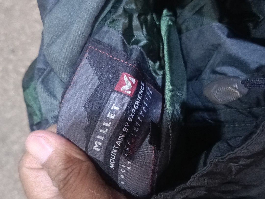 Millet Mountain By Experience Waterproof Outdoor Jacket (Category: Coats, Jackets and Outerwear) located in City of Isabela. Submitted by warmbird.d06e6f (Listing ID 1468548919, Image 3). Description: - Brand: Millet Mountain - Color: Dark grey and black with green inner hood lining - Features: Hood with adjustable drawstrings and secure zip chest pockets - Material: Weather-resistant shell fabric - Best For: Hiking, camping, and rainy weather.