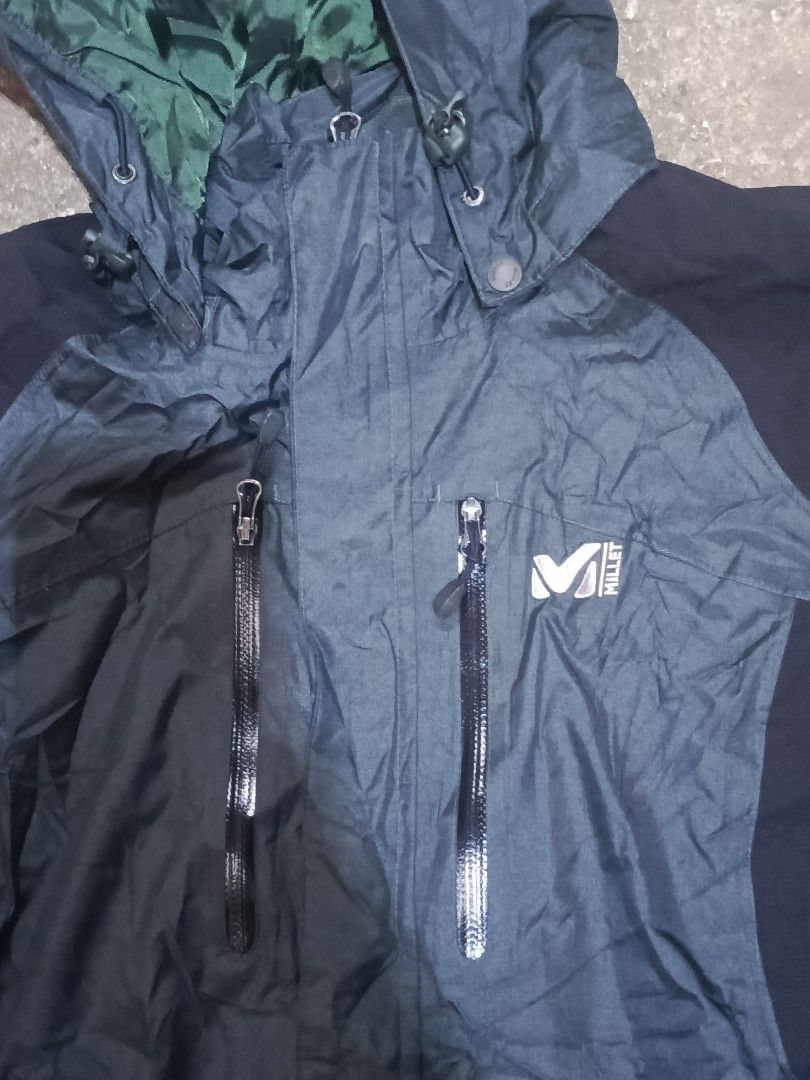 Millet Mountain By Experience Waterproof Outdoor Jacket (Category: Coats, Jackets and Outerwear) located in City of Isabela. Submitted by warmbird.d06e6f (Listing ID 1468548919, Image 2). Description: - Brand: Millet Mountain - Color: Dark grey and black with green inner hood lining - Features: Hood with adjustable drawstrings and secure zip chest pockets - Material: Weather-resistant shell fabric - Best For: Hiking, camping, and rainy weather.