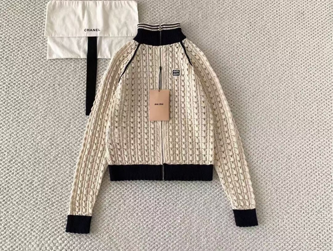 Miu Miu Knit Zip Up Cardigan (Category: Coats, Jackets and Outerwear) located in Malabon City. Submitted by ojaswibent53454 (Listing ID 1468556883, Image 1). Description: - Brand new cream crochet knit cardigan - Contrast navy blue ribbed collar, cuffs, and hem - Full front zipper closure - Signature Miu Miu logo patch on the chest - Long raglan sleeves with seam piping - Includes original hang tag and dust bag.