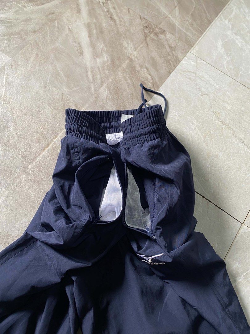 Mizuno Navy Blue Nylon Track Pants (Category: Joggers) located in Butuan. Submitted by jc13thrifts (Listing ID 1468709138, Image 3). Description: - Brand: Mizuno - Color: Navy blue - Size: 30-34 - Material: Lightweight nylon with breathable white mesh lining - Waist: Elastic waistband with an adjustable drawstring - Pockets: Two secure side zip pockets - Hem: Adjustable drawstrings at the ankle cuffs for a custom fit - Details: Embroidered Mizuno