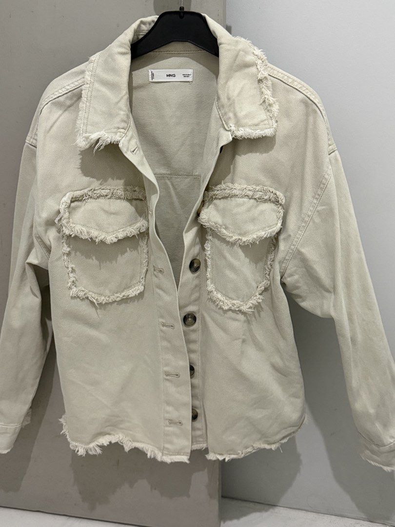 MNG Mango Denim Jacket Raw Hem Cream Beige XS (Category: Coats, Jackets and Outerwear) located in Mandaluyong City. Submitted by trovebya (Listing ID 1468595321, Image 1). Description: - Brand: Mango - Item: Cream denim jacket - Size: XS - Origin: Made in Bangladesh - Design: Button-up front, two chest pockets, and raw frayed edge details on the collar, pockets, hem, and back seam - Style: Great casual layering piece.