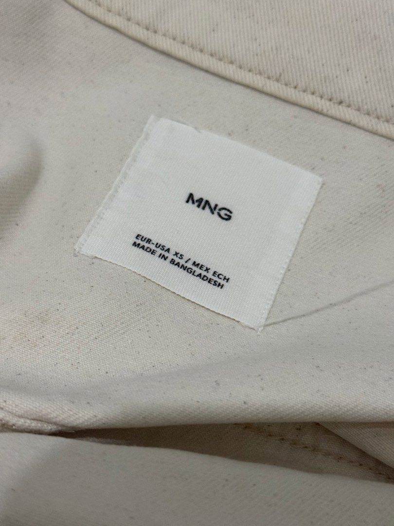 MNG White Denim Jacket Size XS (Category: Coats, Jackets and Outerwear) located in Mandaluyong City. Submitted by trovebya (Listing ID 1468594821, Image 3). Description: - Brand/Style: MNG denim jacket - Color: Off-white - Size: XS - Closure: Front button-up - Pockets: Two chest flap pockets and side slip pockets - Details: Classic collar neck style, made in Bangladesh - Condition: Clean look, versatile for casual outfits.