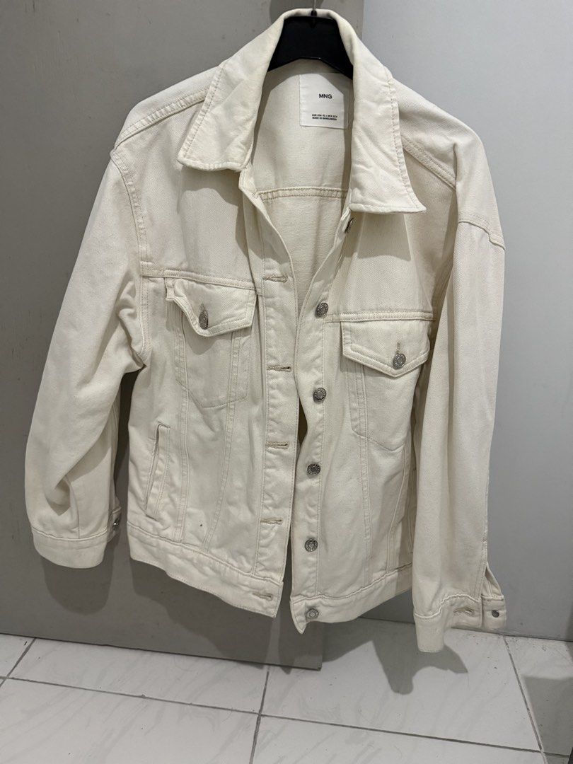 MNG White Denim Jacket Size XS (Category: Coats, Jackets and Outerwear) located in Mandaluyong City. Submitted by trovebya (Listing ID 1468594821, Image 1). Description: - Brand/Style: MNG denim jacket - Color: Off-white - Size: XS - Closure: Front button-up - Pockets: Two chest flap pockets and side slip pockets - Details: Classic collar neck style, made in Bangladesh - Condition: Clean look, versatile for casual outfits.
