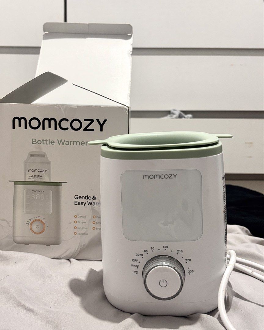 Momcozy Bottle Warmer (Category: Breastfeeding & Bottle Feeding) located in Caloocan City. Submitted by yangcmt (Listing ID 1468637158, Image 1). Description: - Brand: Momcozy - Color: White and green - Condition: Comes with original box - Control: Rotary dial with ml settings (30ml-330ml), food, and timer modes - Power: Plug-in cable - Features: Fast and safe bottle warming at home.