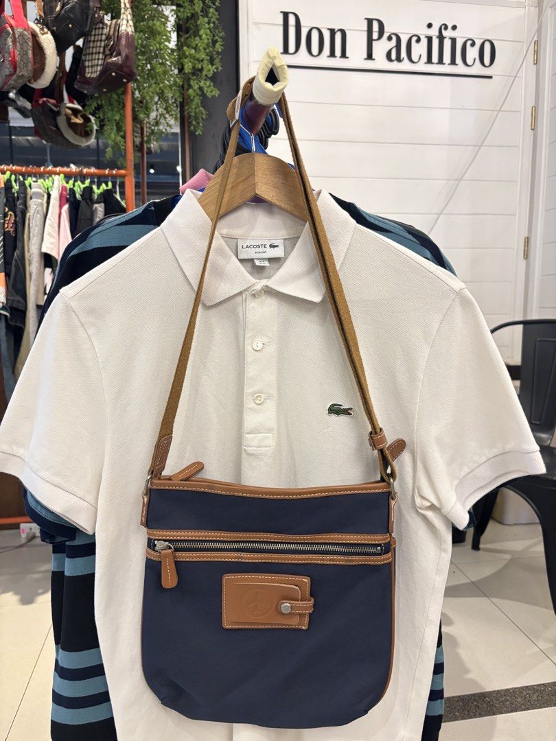 Navy Blue and Brown Crossbody Bag (Category: Cross-body Bags) located in Manila. Submitted by jeromskito66462 (Listing ID 1468676978, Image 1). Description: - Brand: Viam - Color: Navy blue body with stylish brown trim and strap - Closure: Secure magnetic flap with front square patch detail - Pockets: Front zipper pocket, front slip pocket, and inner zipper pocket - Interior: Brown fabric lining - Condition/Use: Great casual everyday bag.