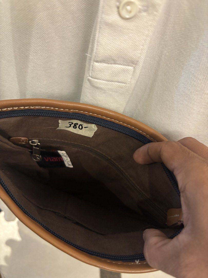 Navy Blue and Brown Crossbody Bag (Category: Cross-body Bags) located in Manila. Submitted by jeromskito66462 (Listing ID 1468676978, Image 3). Description: - Brand: Viam - Color: Navy blue body with stylish brown trim and strap - Closure: Secure magnetic flap with front square patch detail - Pockets: Front zipper pocket, front slip pocket, and inner zipper pocket - Interior: Brown fabric lining - Condition/Use: Great casual everyday bag.