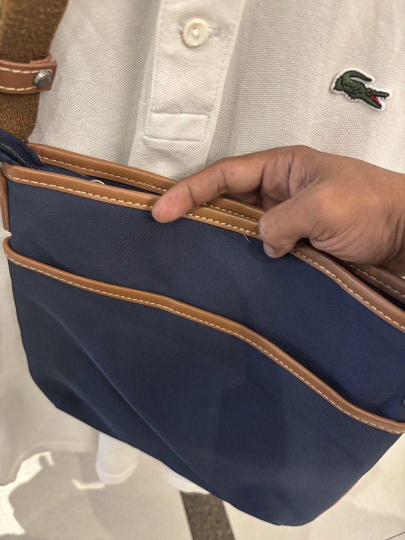 Navy Blue and Brown Crossbody Bag (Category: Cross-body Bags) located in Manila. Submitted by jeromskito66462 (Listing ID 1468676978, Image 2). Description: - Brand: Viam - Color: Navy blue body with stylish brown trim and strap - Closure: Secure magnetic flap with front square patch detail - Pockets: Front zipper pocket, front slip pocket, and inner zipper pocket - Interior: Brown fabric lining - Condition/Use: Great casual everyday bag.
